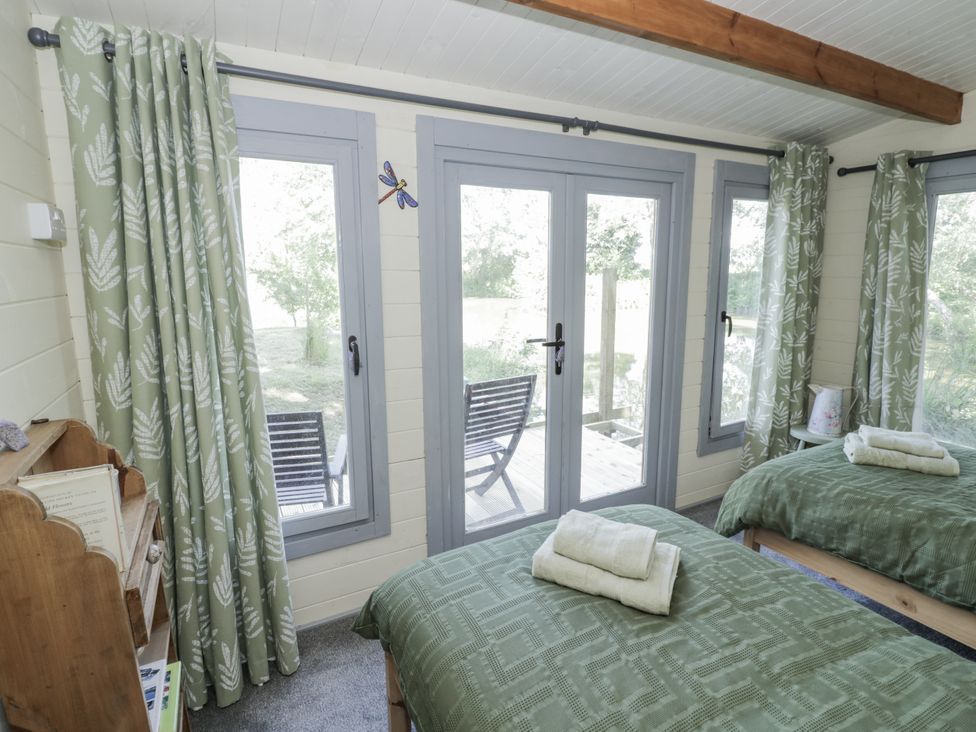 A bedroom with two beds and windows leading outside at The Lodge in 
