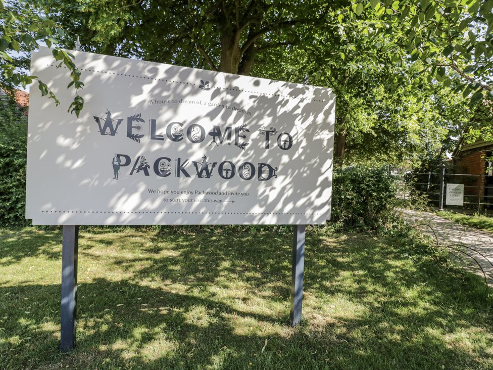 A welcome sign at Packwood with greenery and a pathway