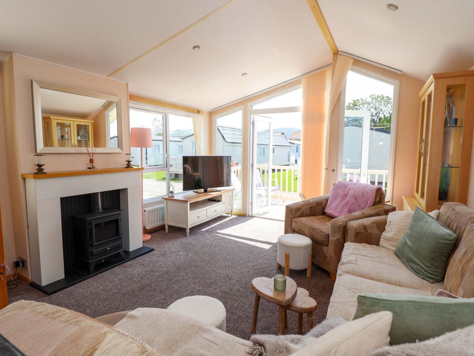 A living room with a tv and a fireplace at 152 Central Park in Prestatyn