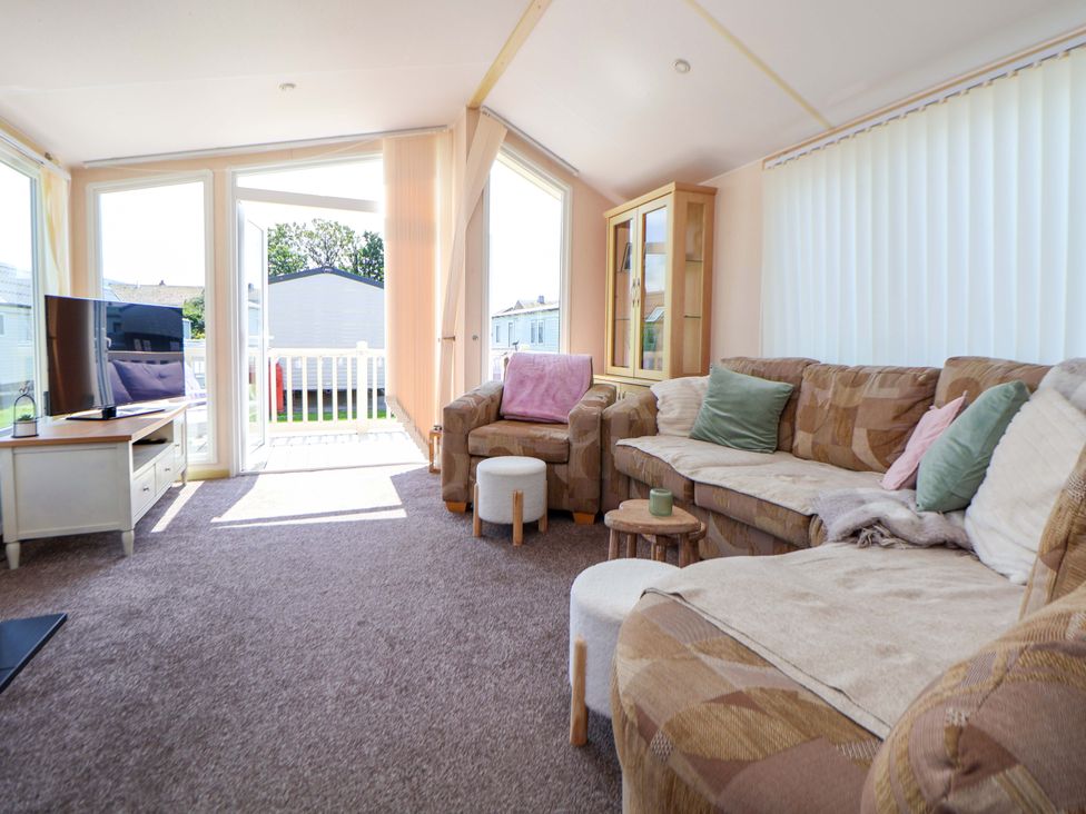 A living room with a sofa and television at 152 Central Park, Prestatyn