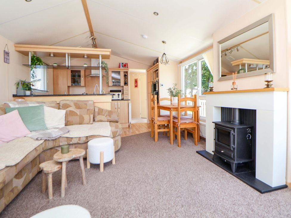 A living room with a sofa and dining table at 152 Central Park in Prestatyn