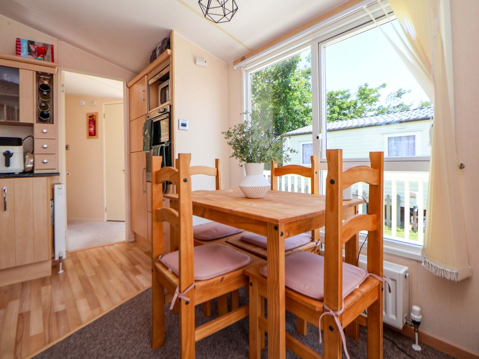 A dining room with a table and chairs at 152 Central Park Prestatyn