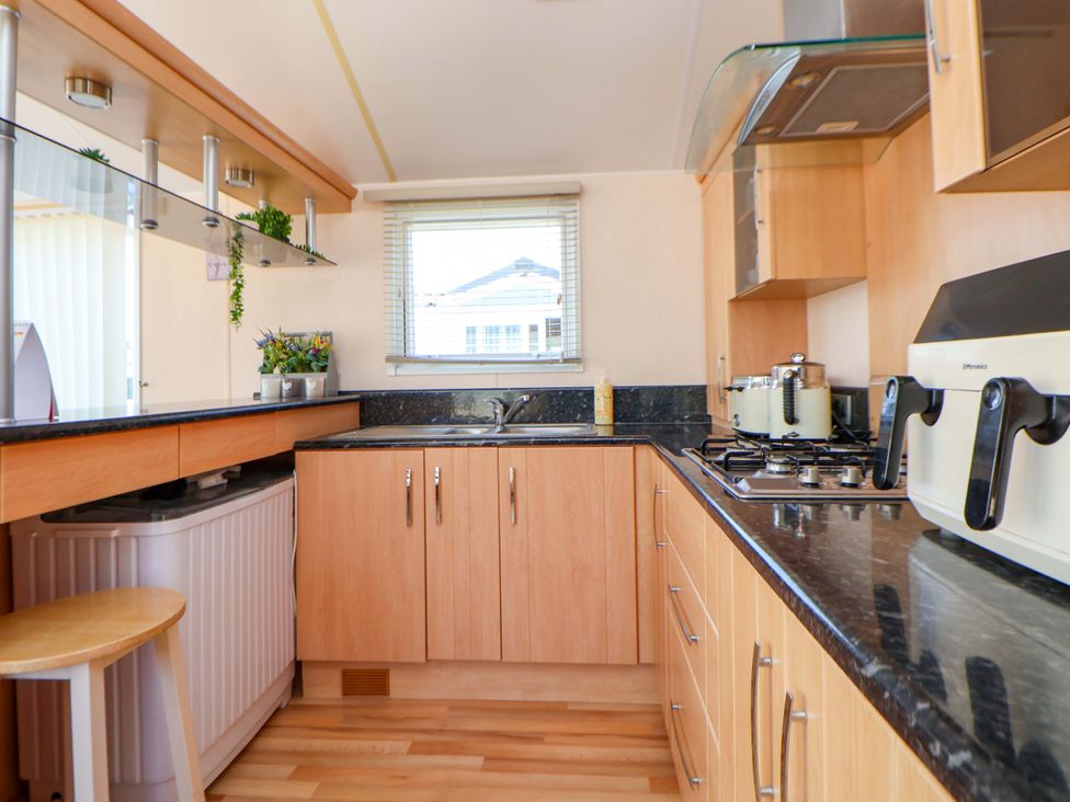 A kitchen with cabinets and a sink at 152 Central Park Prestatyn