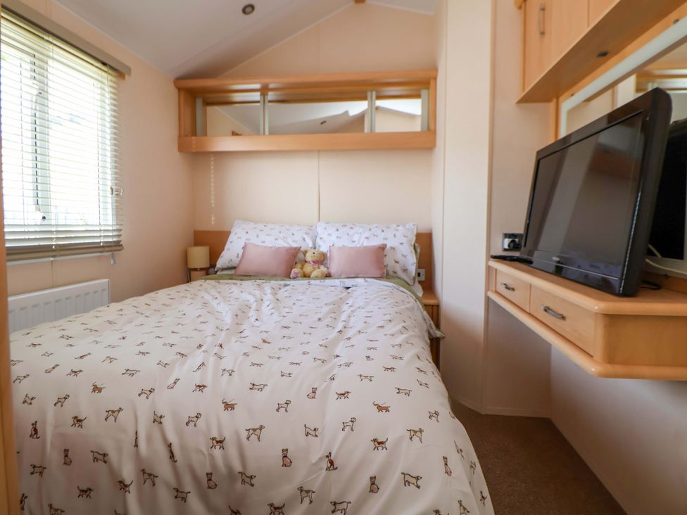 A bedroom with a bed and television at 152 Central Park in Prestatyn