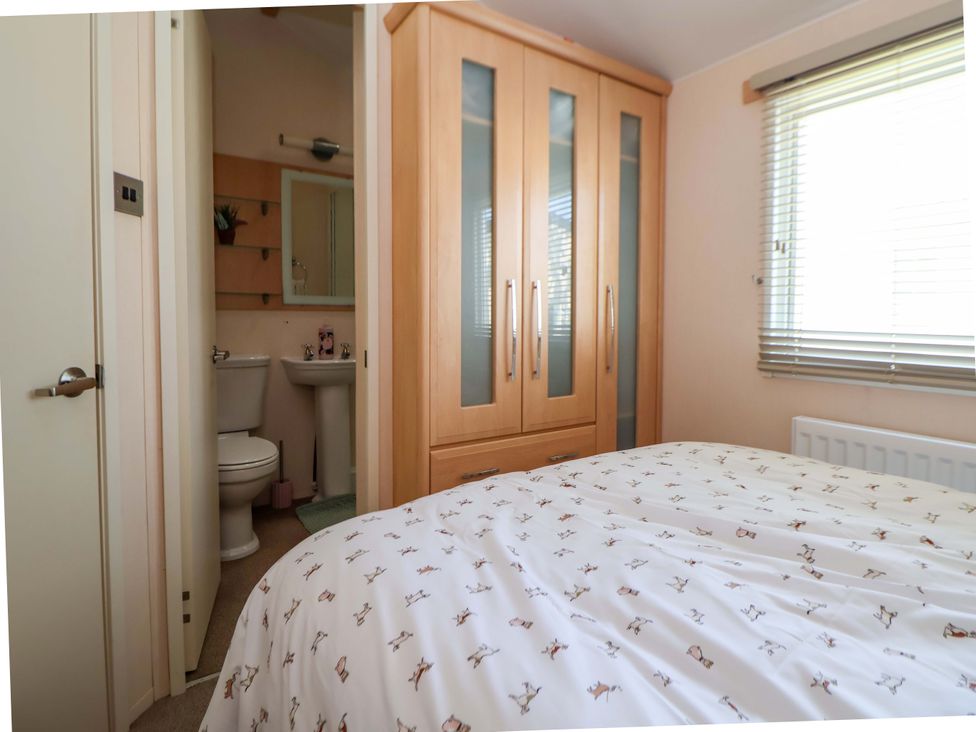 A bedroom with a bed and wardrobe at 152 Central Park in Prestatyn