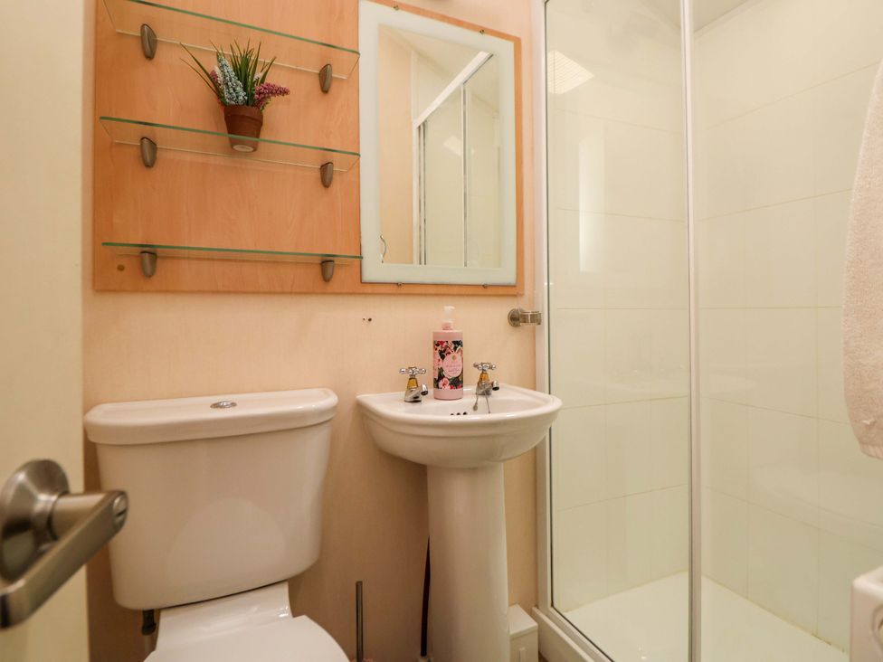 A bathroom with a toilet, sink, and shower at 152 Central Park in Prestatyn