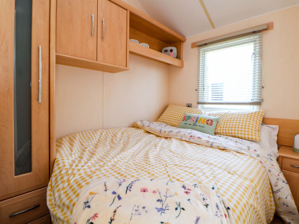 A bedroom with bed and shelves at 152 Central Park in Prestatyn