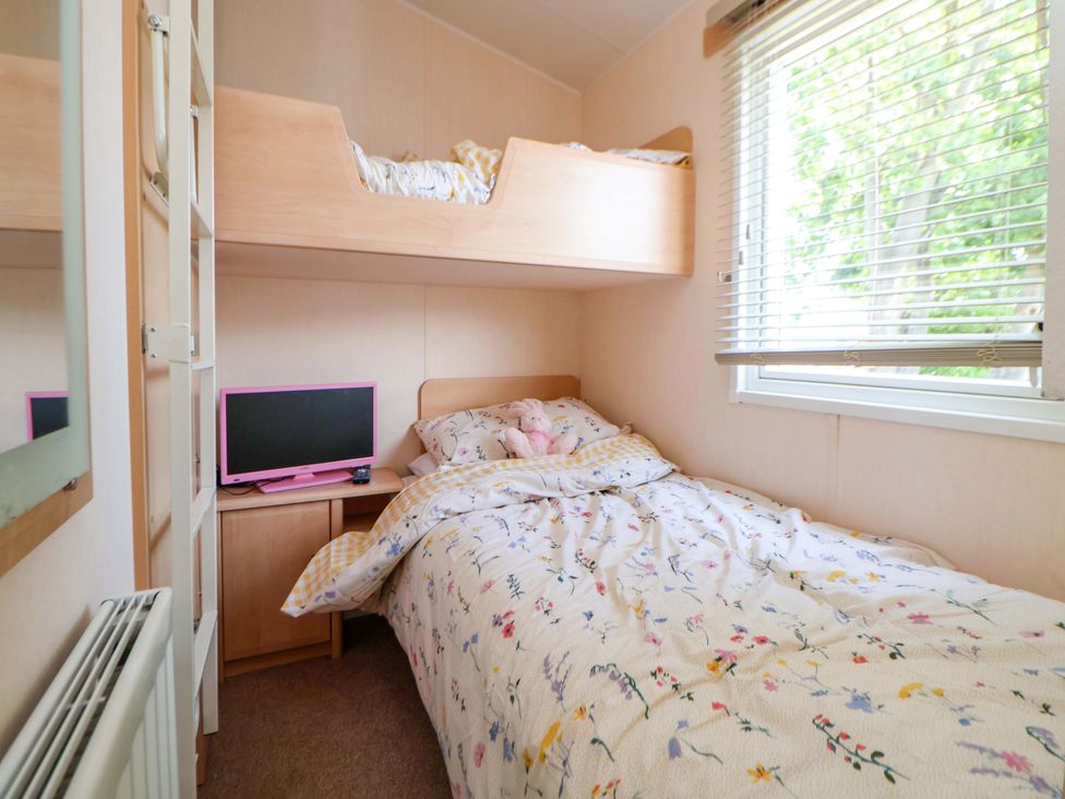 A bedroom with a bunk bed and television at 152 Central Park in Prestatyn