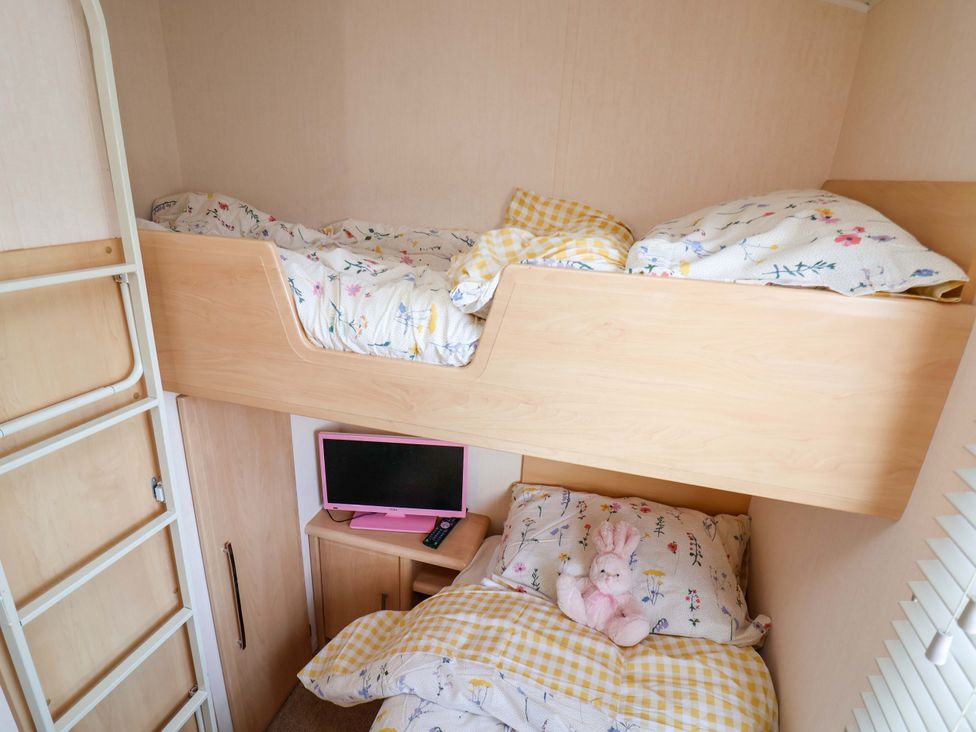 A bedroom with a bunk bed and a television at 152 Central Park, Prestatyn