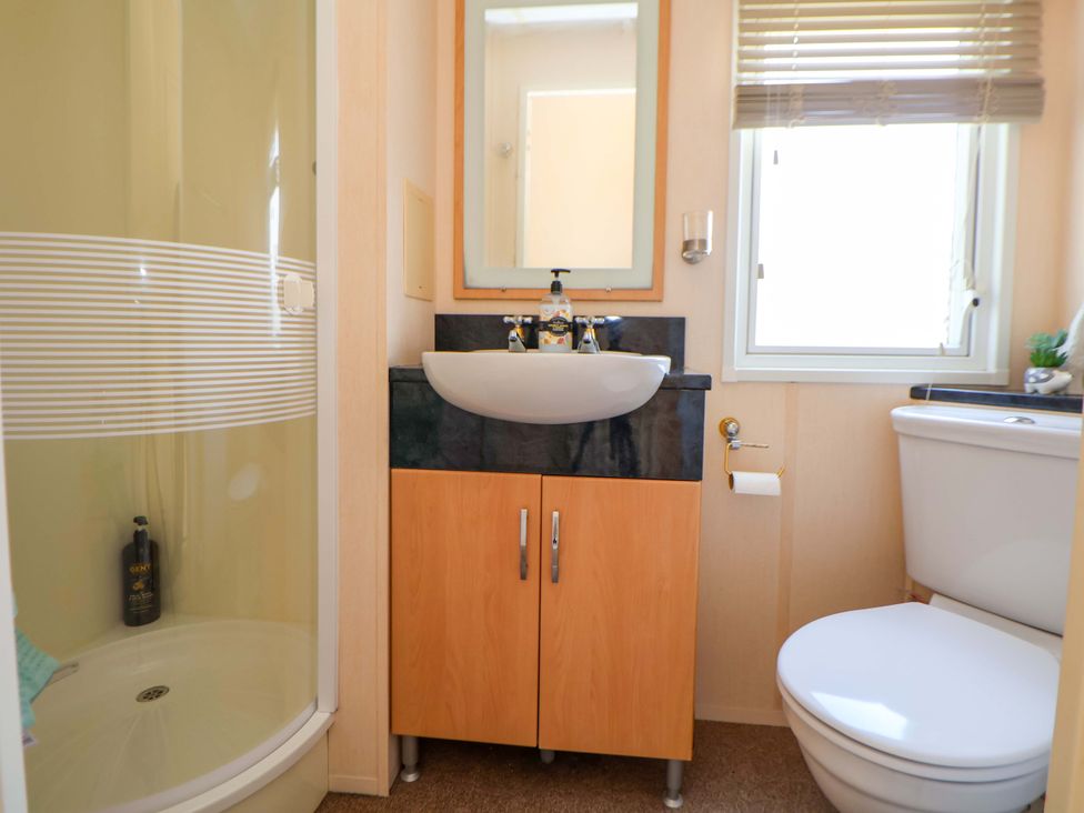 A bathroom with a shower sink and toilet at 152 Central Park in Prestatyn