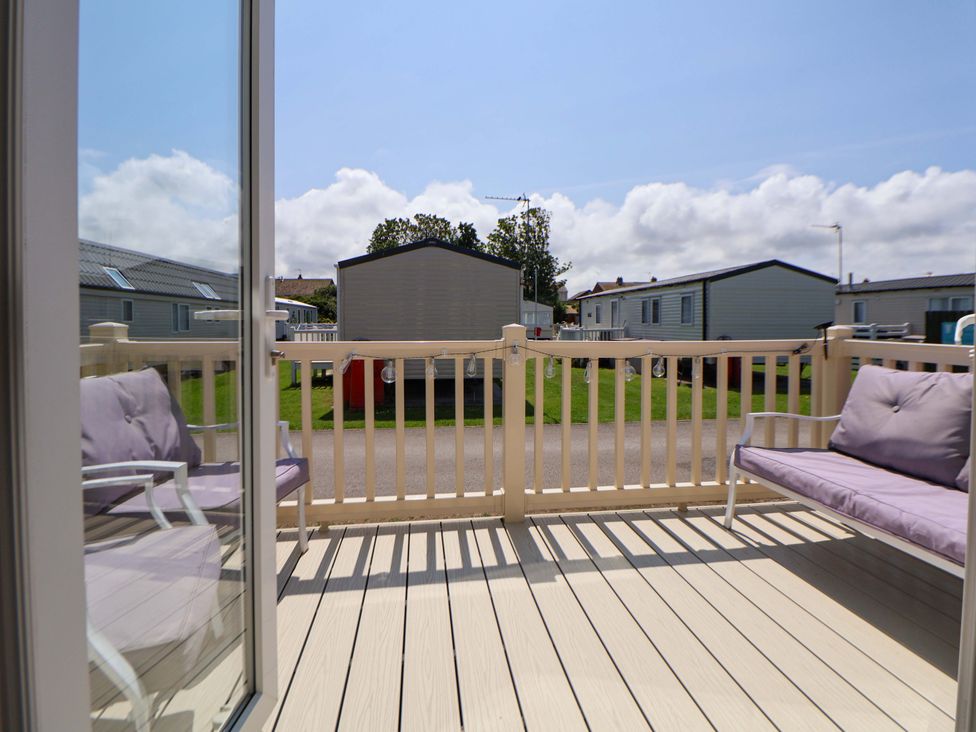 A balcony with seating overlooking caravans at 152 Central Park in Prestatyn