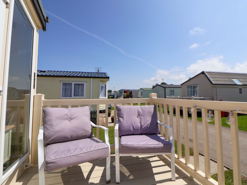 A seating area on a balcony with two chairs at 152 Central Park in Prestatyn