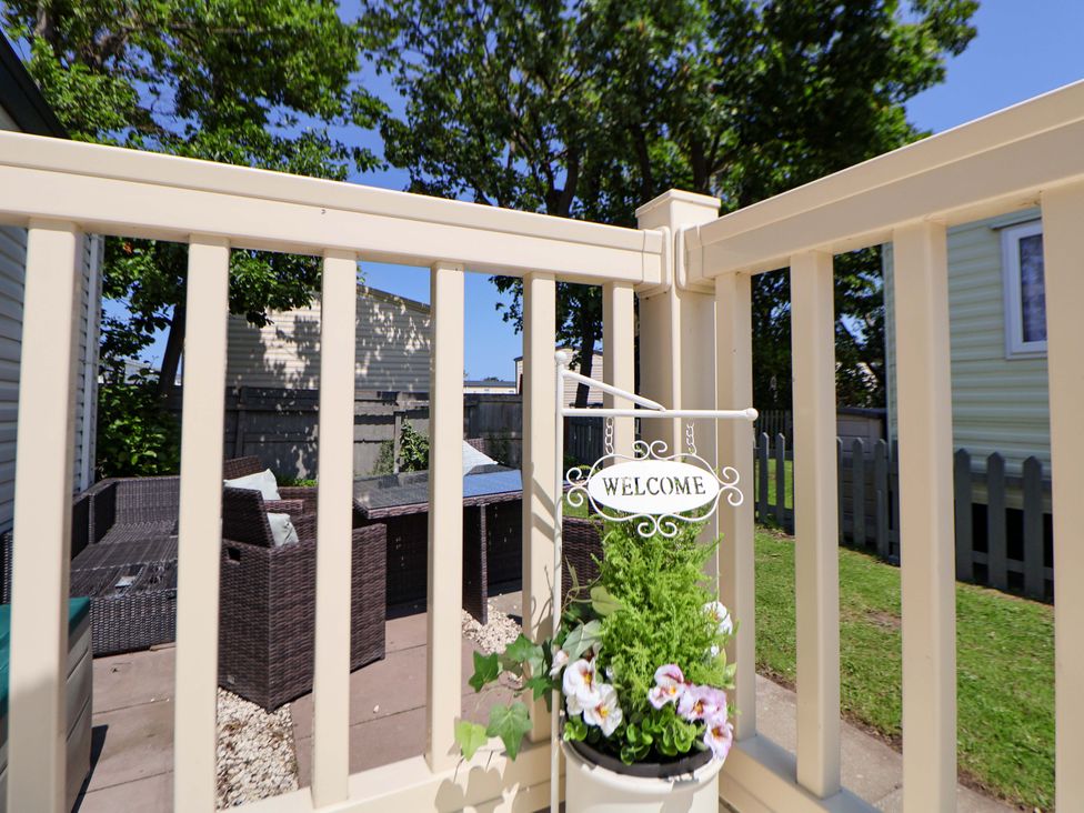 A garden with outdoor furniture and a welcome sign at 152 Central Park in Prestatyn
