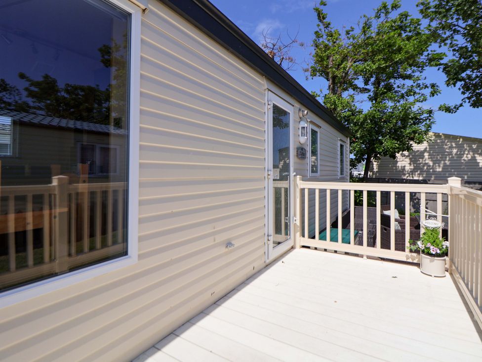 An outdoor deck with a railing and planter at 152 Central Park in Prestatyn