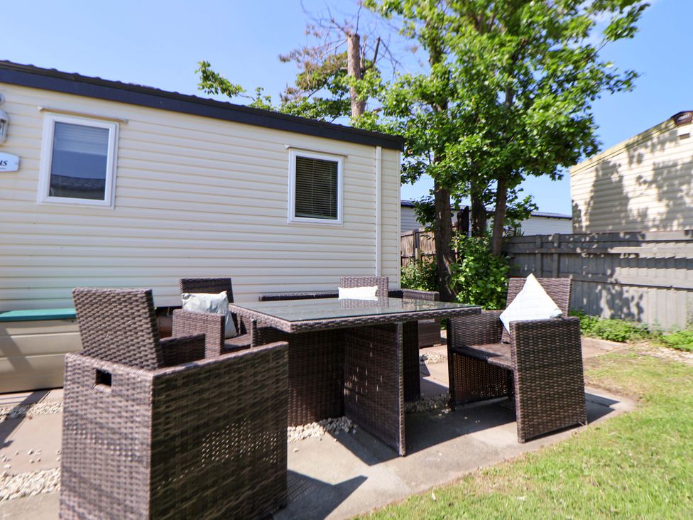 An outdoor dining area with a table and chairs at 152 Central Park in Prestatyn