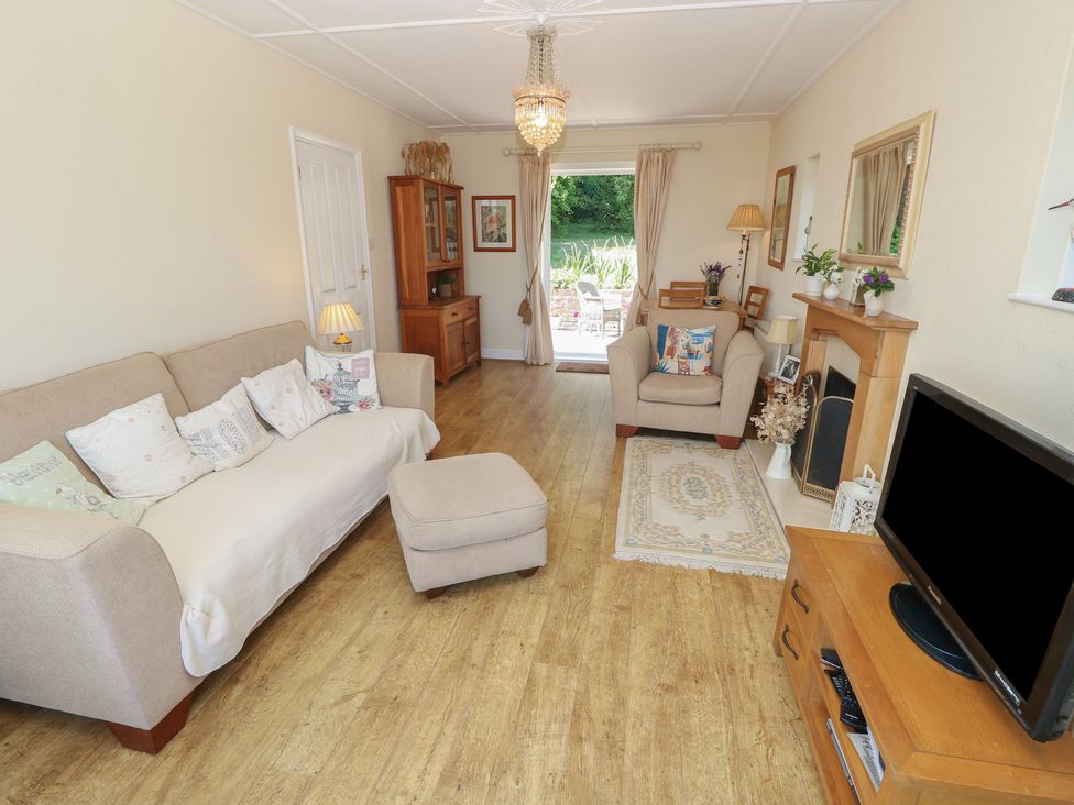 A living room with a sofa and television at Poppy Cottage Ventnor