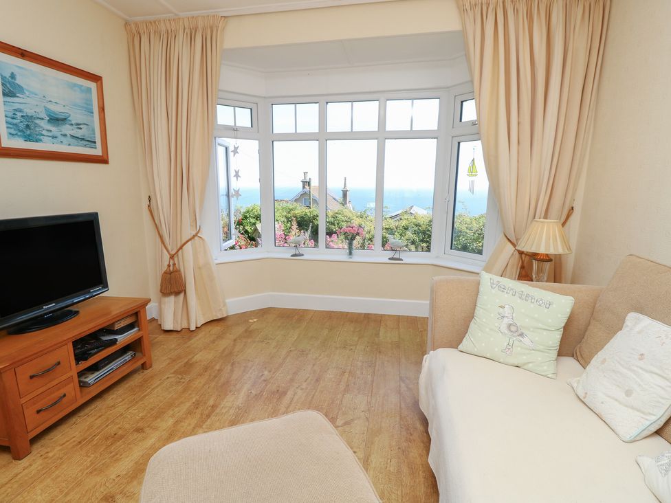 A living room with a window view at Poppy Cottage in Ventnor