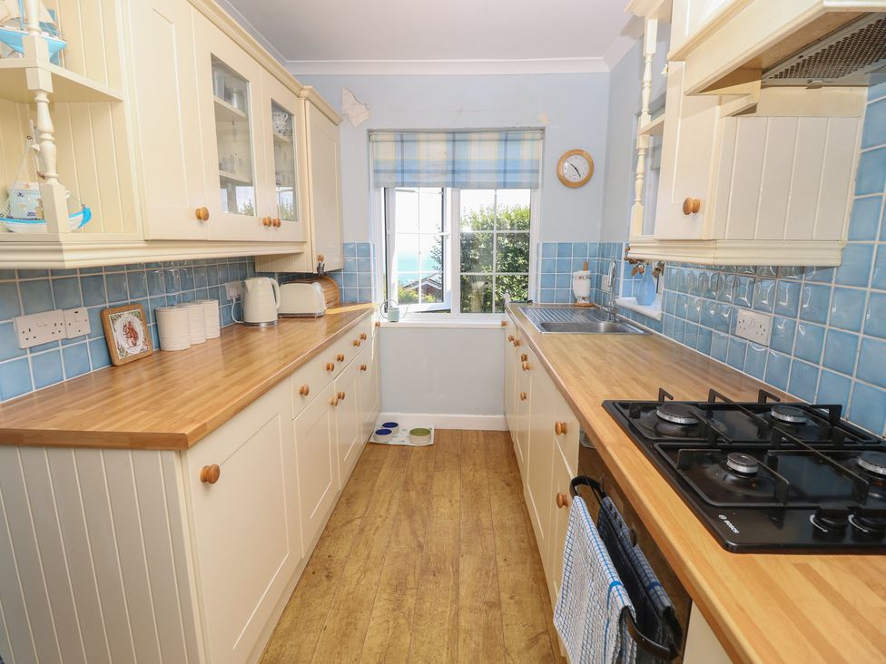 A kitchen with countertops and a window at Poppy Cottage Ventnor