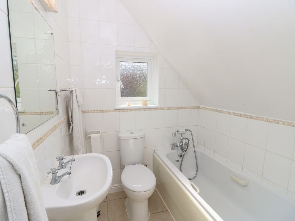 A bathroom with a sink, toilet, and bathtub at Poppy Cottage in Ventnor