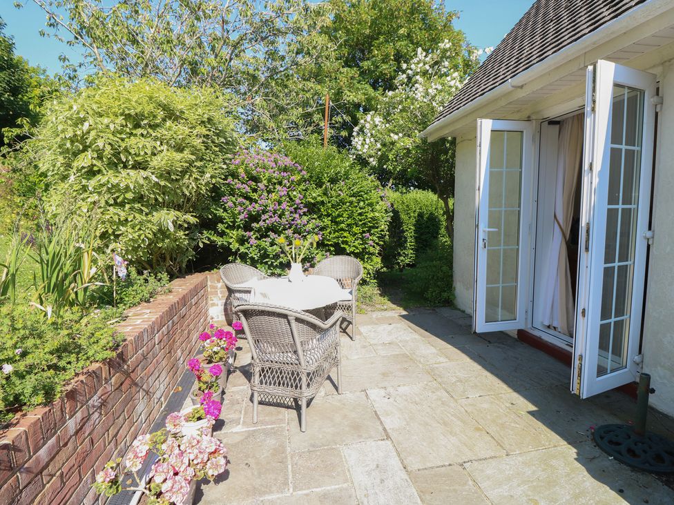 A garden area with a table and chairs at Poppy Cottage Ventnor