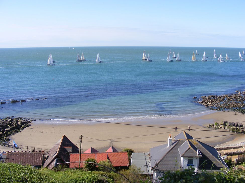 A beach with sailing boats on the water at Poppy Cottage in Ventnor
