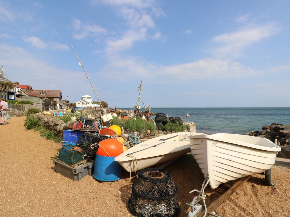A view of boats, fishing equipment, and ocean at Poppy Cottage in Ventnor
