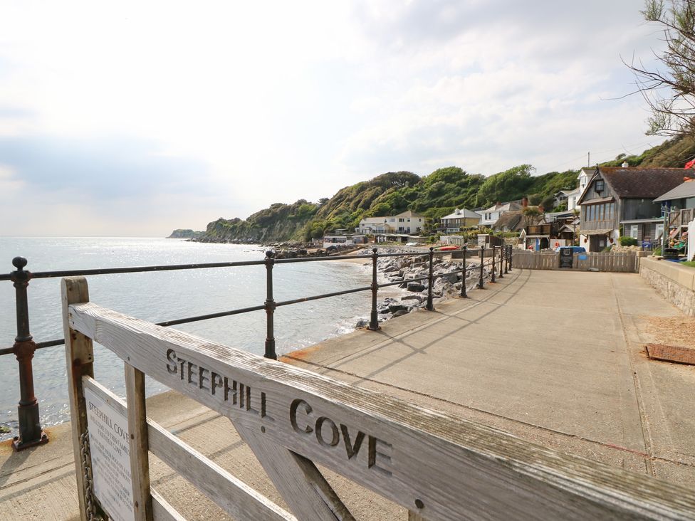 A coastal pathway with houses and rocks at Steephill Cove in Ventnor