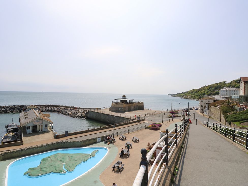 A seaside view with a pier and buildings at Poppy Cottage in Ventnor