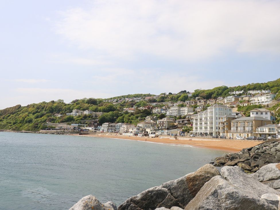 A view of a beach and buildings along the shoreline at Poppy Cottage in Ventnor