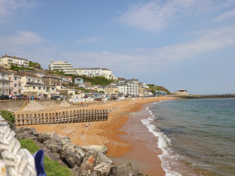 A beach with buildings and water at Poppy Cottage in Ventnor