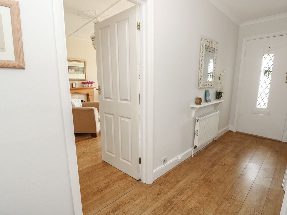 A hallway with a door and mirror at Poppy Cottage Ventnor