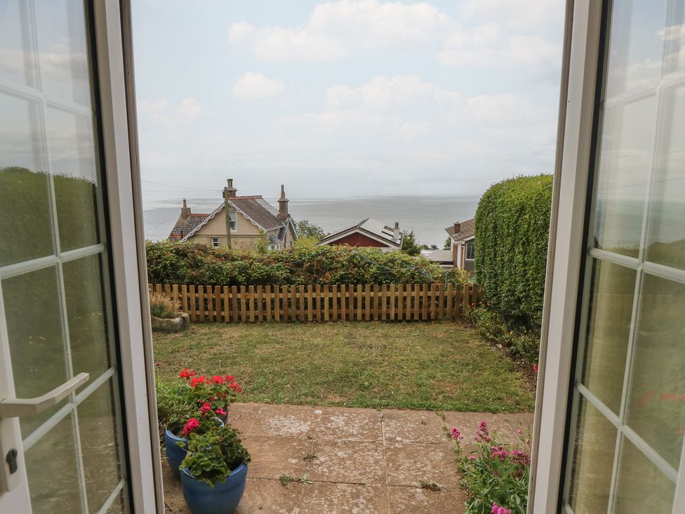 A view of the garden and sea from a door at Poppy Cottage in Ventnor