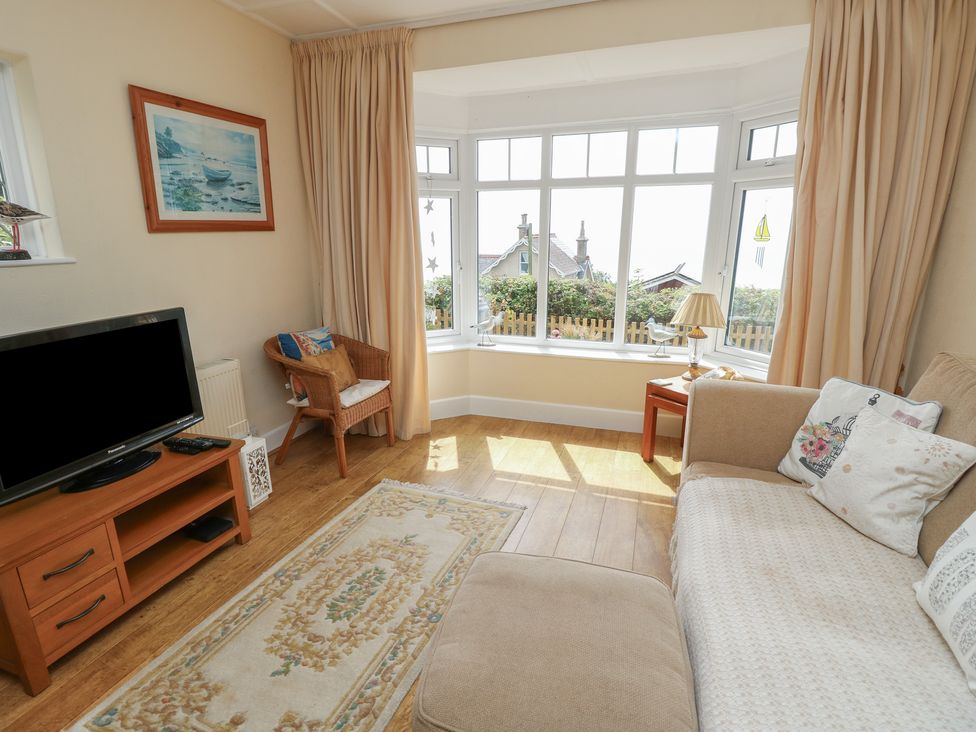 A living room with a television and sofa at Poppy Cottage in Ventnor