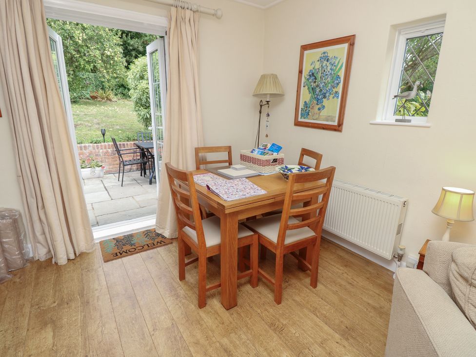 A dining room with a table and chairs at Poppy Cottage Ventnor
