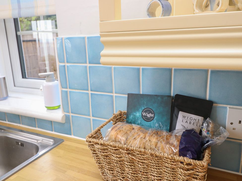 A kitchen with bread in a basket and soap dispenser at Poppy Cottage in Ventnor