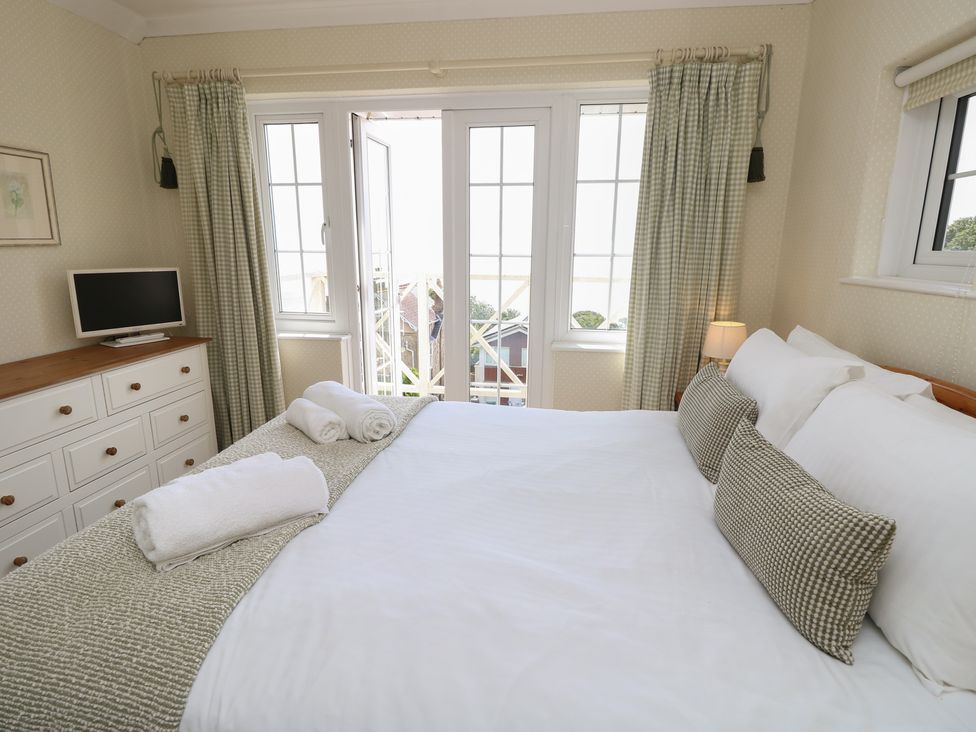 A bedroom with a bed and television at Poppy Cottage in Ventnor