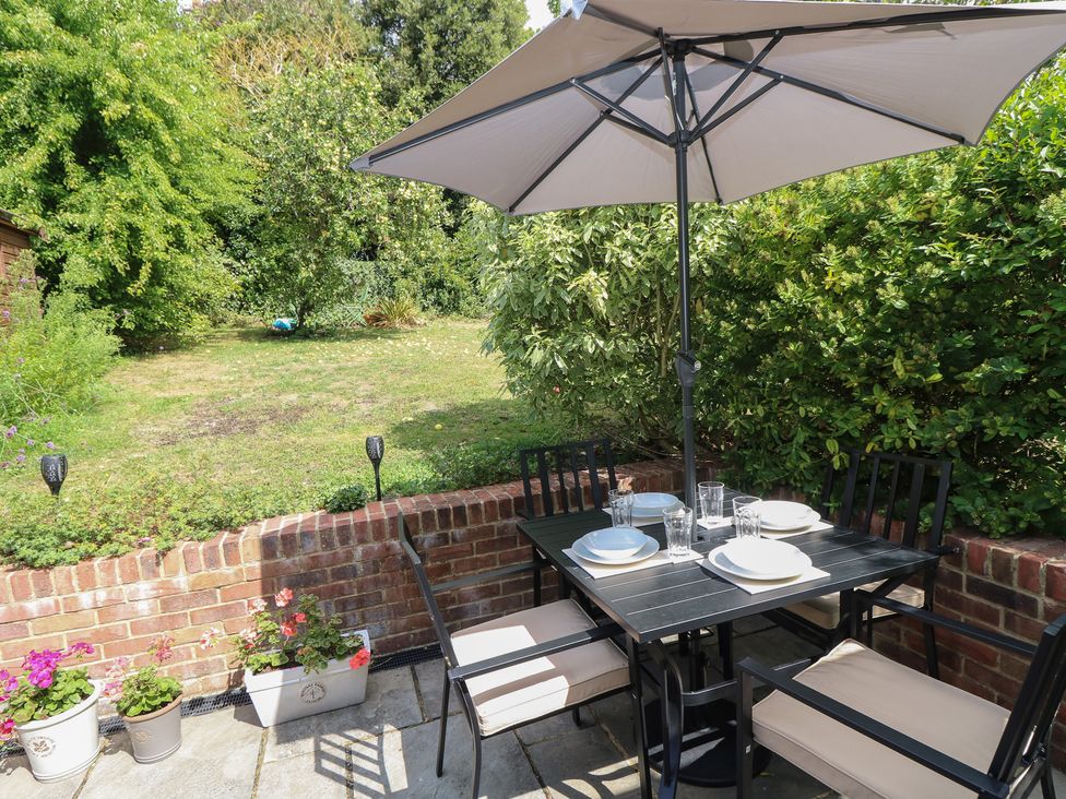 An outdoor dining table with an umbrella at Poppy Cottage in Ventnor