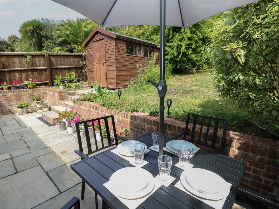 An outdoor dining area with a table and chairs at Poppy Cottage in Ventnor