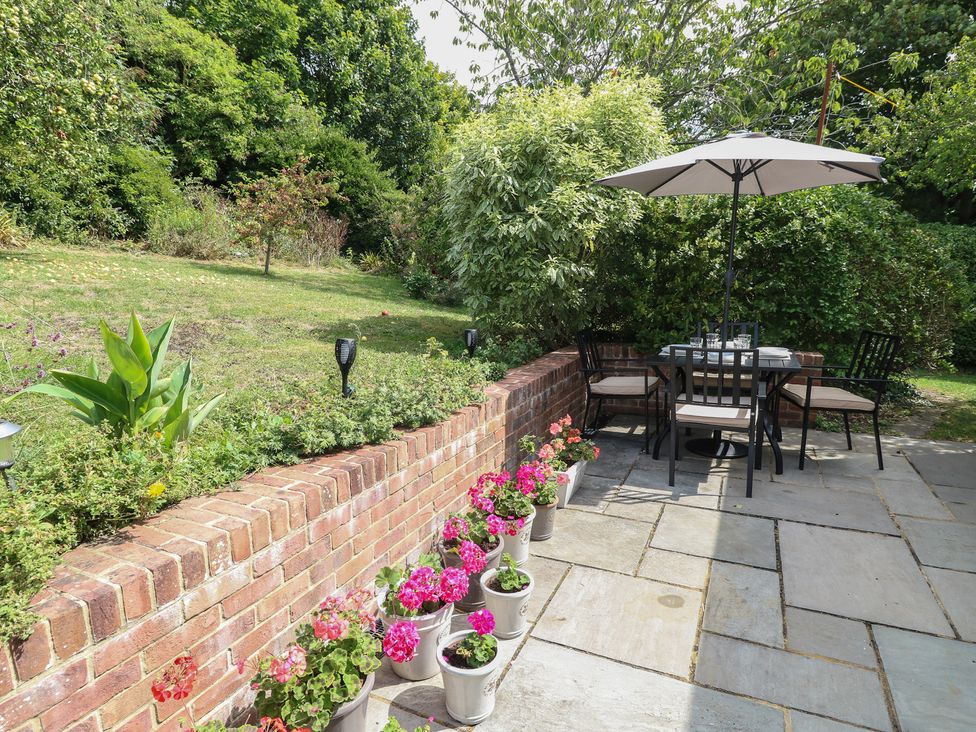 A garden with a seating area and flower pots at Poppy Cottage in Ventnor