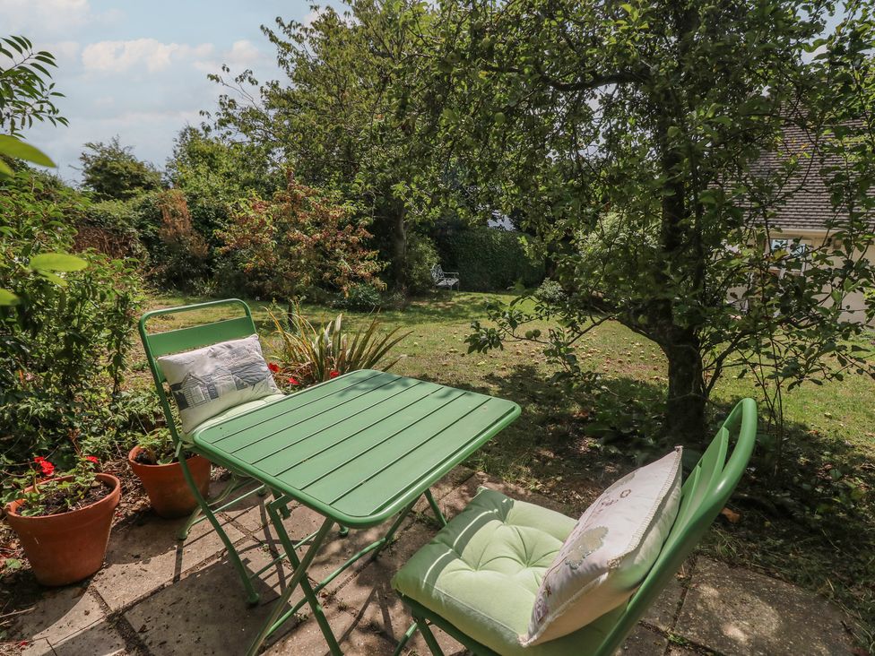 A garden with a green table and chairs at Poppy Cottage Ventnor