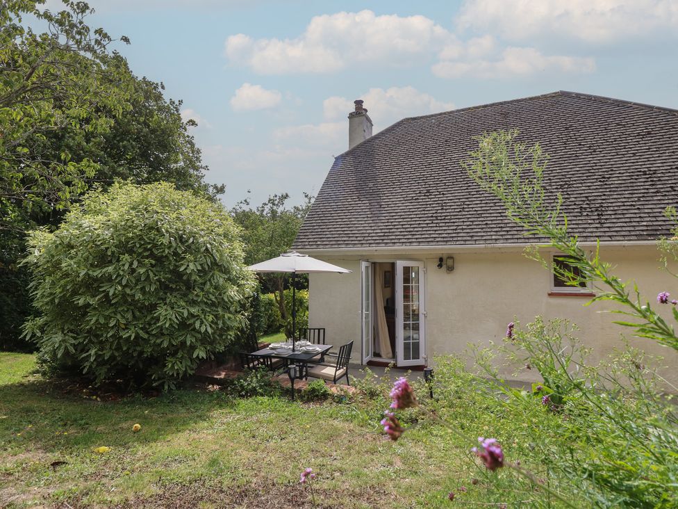 A garden with seating and a house at Poppy Cottage Ventnor