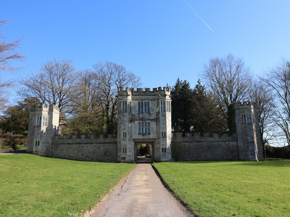 A stone gateway with two side towers and a central archway on a grassy area with trees behind at Megs Roost in Shute near Colyton