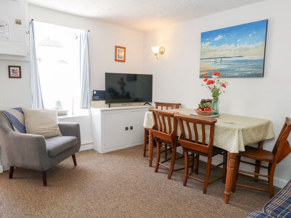 A dining room with a table and chairs at Driftwood in Weymouth