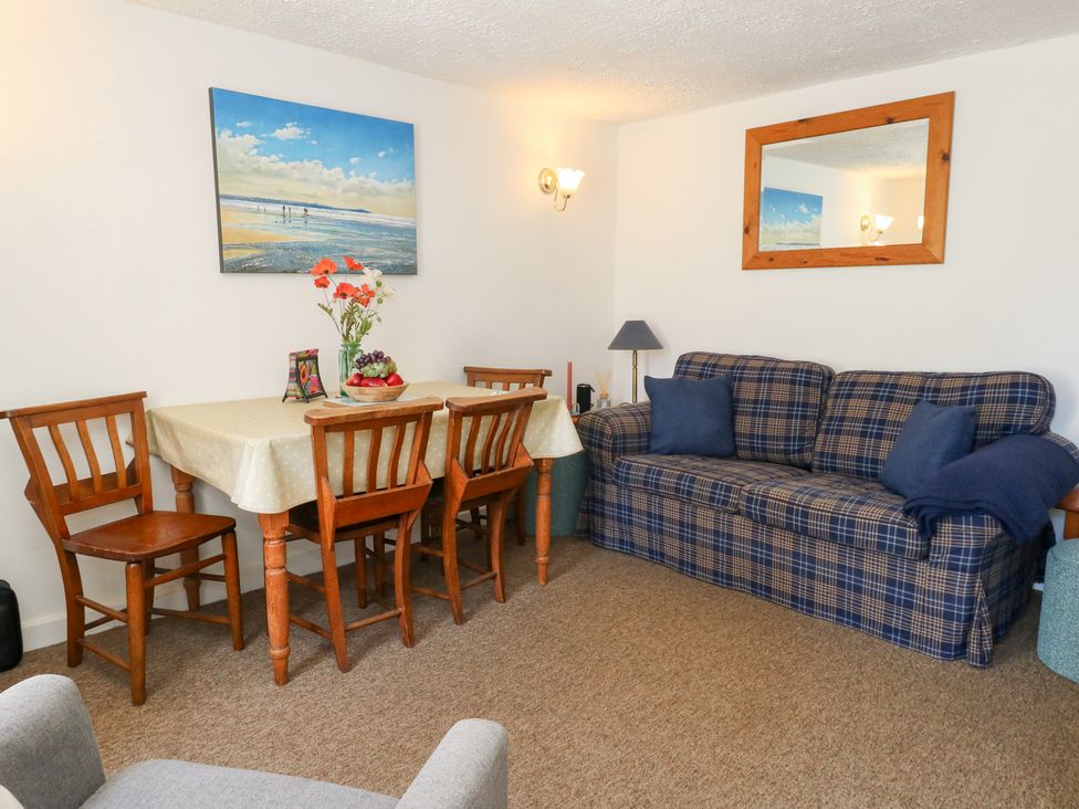 A dining room with table and chairs at Driftwood in Weymouth