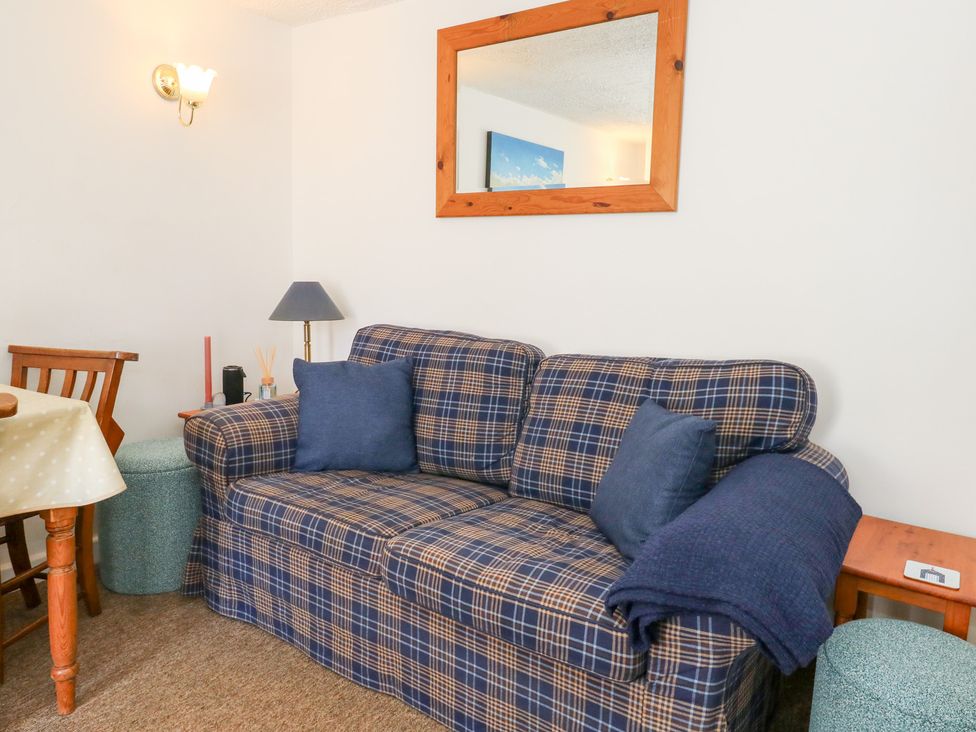 A living room with a sofa and lamp at Driftwood in Weymouth