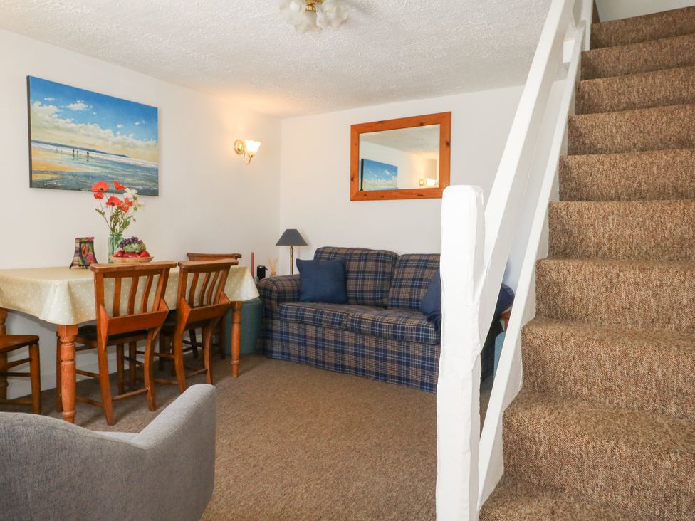 A living room with a sofa and dining area at Driftwood in Weymouth