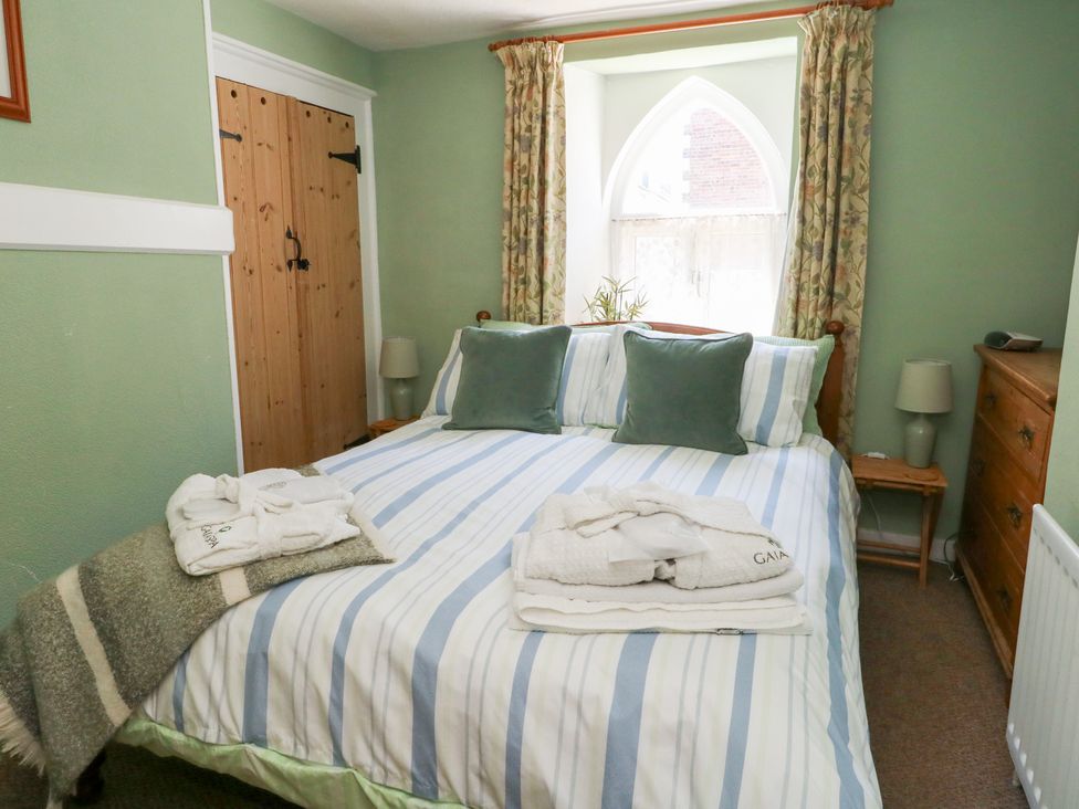 A bedroom with a double bed and wooden furniture at Driftwood in Weymouth
