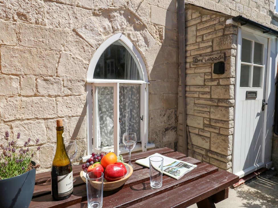 A table with fruit and a bottle outside Driftwood in Weymouth