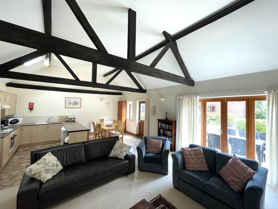 A living room with sofa and dining area at Beechwood in Wood Norton near Foulsham