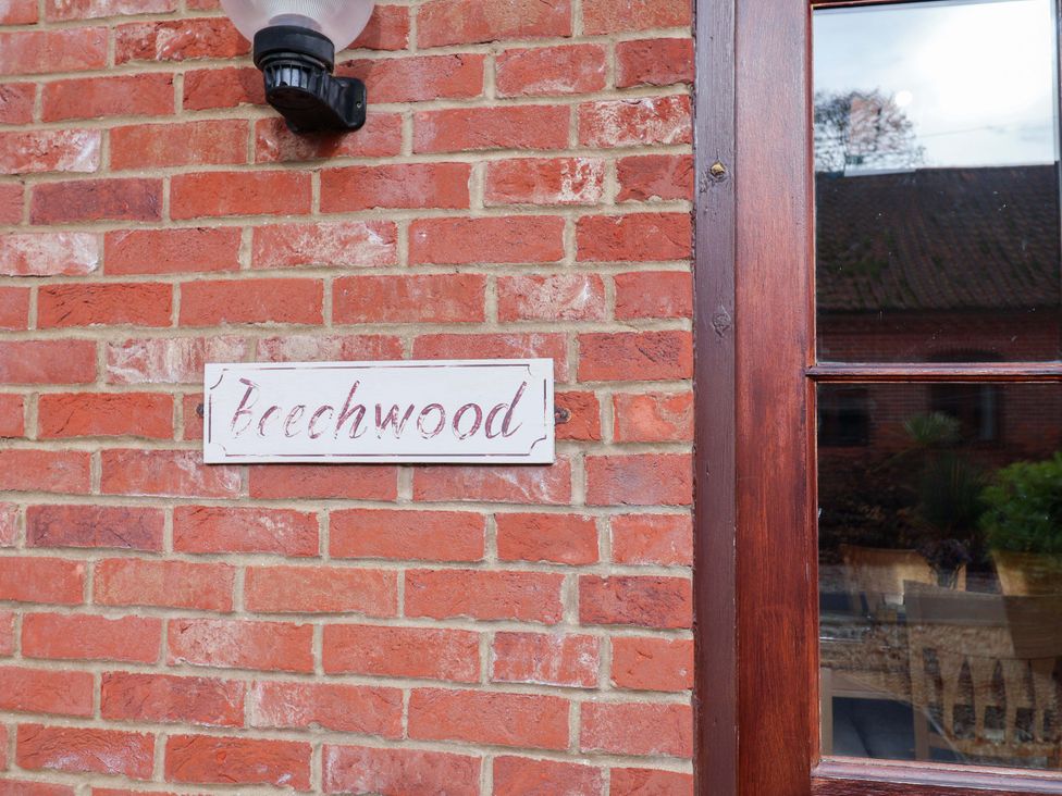 A brick wall with a nameplate reading Beechwood at Beechwood in Wood Norton